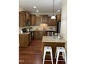 Well-lit kitchen featuring stainless steel appliances, granite countertops, and hardwood floors at 1090 Indigo Ridge Pl, Cary, NC 27519