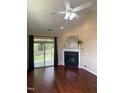 Cozy living room with a fireplace, ceiling fan, and access to a screened-in porch at 1090 Indigo Ridge Pl, Cary, NC 27519