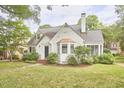Exterior view showcasing a landscaped front yard and well-kept facade with bright white cladding at 1104 Englewood Ave, Durham, NC 27701