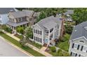 Stunning aerial view of a gray two-story home with a welcoming porch, manicured yard, and lush landscaping at 124 Kingsport Rd, Holly Springs, NC 27540