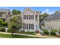 Classic two-story home boasting gray siding, black shutters, a quaint porch, and a well-maintained front yard at 124 Kingsport Rd, Holly Springs, NC 27540