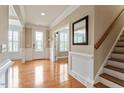Bright foyer features hardwood floors, white wainscoting, and a beautiful front door at 150 Saint Mellion St, Raleigh, NC 27603
