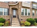 Charming front entrance with stone steps, black door with glass and stone and brick accents at 150 Saint Mellion St, Raleigh, NC 27603