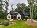 A modern farmhouse-style house with a white brick exterior, black accents, and a well-maintained lawn at 153 W Beech Slope Ct, Chapel Hill, NC 27517