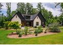 Beautifully landscaped front yard with lush plants complements the modern farmhouse style of this home at 153 W Beech Slope Ct, Chapel Hill, NC 27517