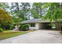 Side view of single-story home with covered parking, green trim, and a well-manicured lawn at 1606 Sycamore St, Durham, NC 27707