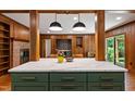 Open-concept kitchen featuring a marble island, wood-paneled walls, and modern pendant lighting at 1606 Sycamore St, Durham, NC 27707