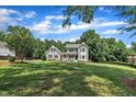Inviting two-story home with a charming front porch, lush greenery, and a well-maintained lawn in a tranquil setting at 171 St. Jiles Dr, Clayton, NC 27520