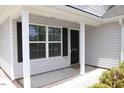 Close-up of a home's entrance featuring a black door, white trim, and manicured shrubs at 1848 Glenn St, Burlington, NC 27217