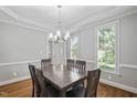 Dining room with wainscoting, hardwood floors, and a chandelier above the table at 202 Stoneleigh Dr, Cary, NC 27511