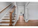Elegant foyer with hardwood floors and staircase leading to a naturally lit hallway at 202 Stoneleigh Dr, Cary, NC 27511