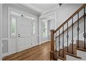 Bright foyer with hardwood floors, white trim, and elegant staircase with black iron spindles at 202 Stoneleigh Dr, Cary, NC 27511