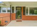 Inviting front porch with brick accents and a glass storm door at 218 Forestville Rd, Wake Forest, NC 27587