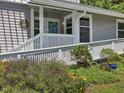 Inviting front entrance with a ramp, white railings, and vibrant flower beds leading to a blue front door at 224 Kirkwood Dr, Chapel Hill, NC 27514