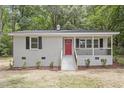 Charming brick home featuring a bright red front door, covered porch, and landscaped front yard at 2702 Red Valley Dr, Rougemont, NC 27572