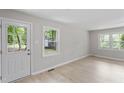 Inviting living room with a glass-paneled door, two windows, and light-colored flooring at 2702 Red Valley Dr, Rougemont, NC 27572