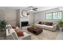Comfortable living room featuring a fireplace, ceiling fan, and large windows at 2905 Scuppernong Ln, Durham, NC 27703