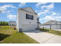 Side angle shot of a two-story home with white siding, an attached garage, and spacious lot at 316 Mimosa Ct, Sanford, NC 27332