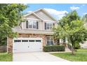 Charming two-story home features a stone facade, well-manicured lawn, and a two-car garage at 3217 Ranbir Dr, Durham, NC 27713