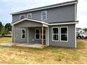 View of the back of the two-story house with gray siding and white trim at 35 Windflower Court Ct # Homesite 9, Clayton, NC 27520