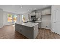 Modern kitchen with gray cabinets, stainless steel appliances, large island, and hardwood floors at 35 Windflower Court Ct # Homesite 9, Clayton, NC 27520