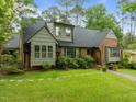 Attractive brick and shingle home featuring a lush green lawn, mature landscaping, and inviting curb appeal at 3516 Swift Dr, Raleigh, NC 27606