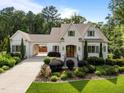 Charming two-story home with manicured landscaping, a light brick facade, and an attached carport at 387 Riverstone Dr, Pittsboro, NC 27312