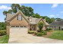 Charming single-Gathering home featuring a brick facade, two car garage, and manicured landscaping at 412 Whitt Ave, Burlington, NC 27215