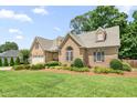 Charming single-Gathering home featuring a brick facade, two car garage, and manicured landscaping at 412 Whitt Ave, Burlington, NC 27215