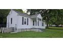 Single-story home featuring white siding, black shutters, covered front porch, and a well-kept lawn at 426 Smith St, Burlington, NC 27217