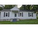 Charming single-story home with white siding, black shutters, and a covered front porch at 426 Smith St, Burlington, NC 27217