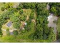Expansive wooded lot featuring mature trees, outbuildings, a charming home, and a serene stream at 4703 Pleasant Green Rd, Durham, NC 27705