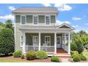 Charming two-story home featuring a welcoming front porch with classic white columns and lush landscaping at 500 Weaver Mine Trl, Chapel Hill, NC 27517