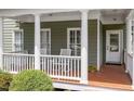 Inviting front porch with classic white columns, wood decking, and charming seating at 500 Weaver Mine Trl, Chapel Hill, NC 27517