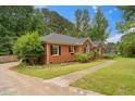 Side view of a brick home with black shutters, arched windows, and a paved walkway at 5405 Doemont Dr, Apex, NC 27539