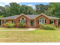 Beautiful brick home with black shutters, arched windows, and landscaped bushes at 5405 Doemont Dr, Apex, NC 27539