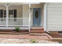 Close-up of the front door of the home, featuring a unique decorative glass insert and brick entryway at 5428 Passenger Pl, Raleigh, NC 27603