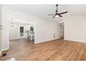 Open-concept living room with modern ceiling fan that connects to a bright kitchen with a breakfast bar at 5428 Passenger Pl, Raleigh, NC 27603
