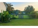 Expansive backyard featuring a large green lawn, mature trees, and a rustic wooden fence at 56 Sugarhill Dr, Zebulon, NC 27597