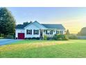 Well-maintained one-story home featuring a manicured front yard, cozy front porch, and an attached garage at 56 Sugarhill Dr, Zebulon, NC 27597