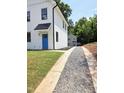 Gravel driveway leading to two-story home featuring black trim and a bright blue front door at 608 A E Umstead, Durham, NC 27701