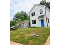 A two-story home featuring black trimmed windows and a bright blue front door on a well-manicured lawn at 608 A E Umstead, Durham, NC 27701