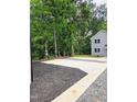 A parking area with both gravel and mulch leading to a home with black trim and a blue front door at 608 A E Umstead, Durham, NC 27701