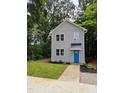Charming two-story home featuring a bright blue front door, complemented by manicured landscaping and lush trees at 608 E Umstead St, Durham, NC 27701