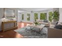 Bright living room featuring hardwood floors, large windows, and elegant furnishings at 6605 Huntingridge Rd, Chapel Hill, NC 27517