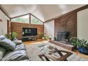 Cozy living room featuring a brick fireplace, large windows, and a comfortable seating area with stylish decor at 6701 Winding Trail Trl, Raleigh, NC 27612