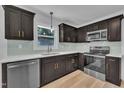 Modern kitchen with stainless steel appliances, quartz countertops, and dark wood cabinets with gold hardware at 802 Creech Church Rd, Kenly, NC 27542