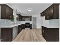 Stylish kitchen featuring stainless steel appliances, quartz countertops, dark cabinets and blue glass tile backsplash at 802 Creech Church Rd, Kenly, NC 27542