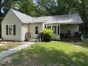 Cozy one-story home with a metal roof, charming front porch, and small, landscaped yard at 981 Leasburg Rd, Roxboro, NC 27573