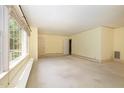 Spacious room with a large window, neutral-colored walls and carpet, plus two interior doors at 103 E Meadowbrook Dr, Smithfield, NC 27577